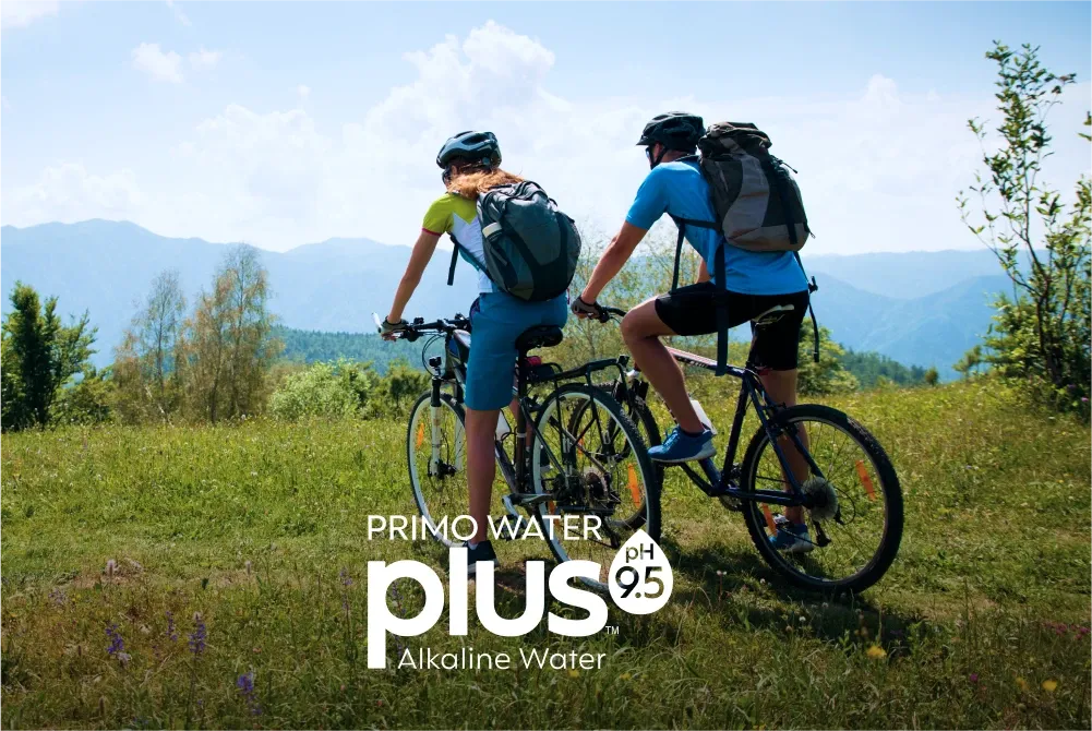 Cyclists on a mountaintop with Primo Water Plus Alkaline Water logo PH 9.5