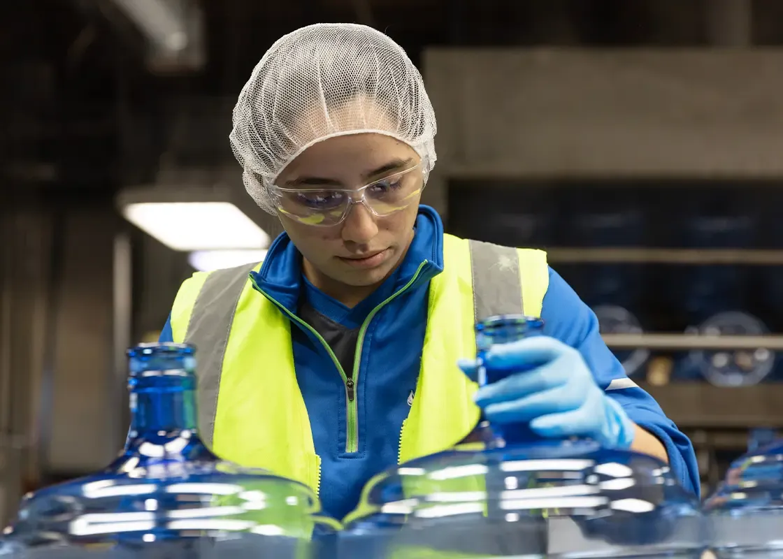 Woman cleaning and sanitizing Primo Water Bottles for reuse