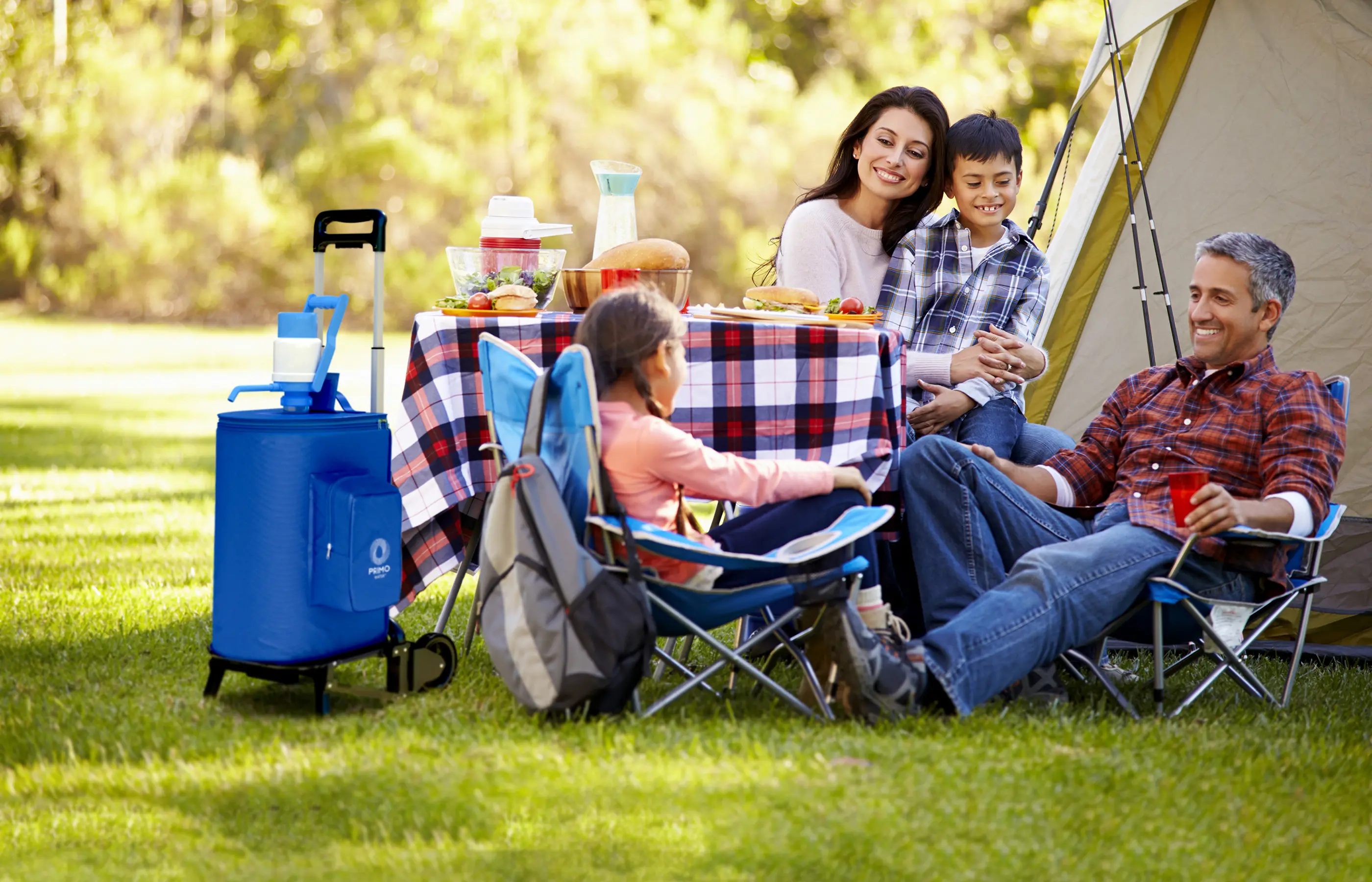 Family enjoying a meal while camping with a Primo portable water dispenser